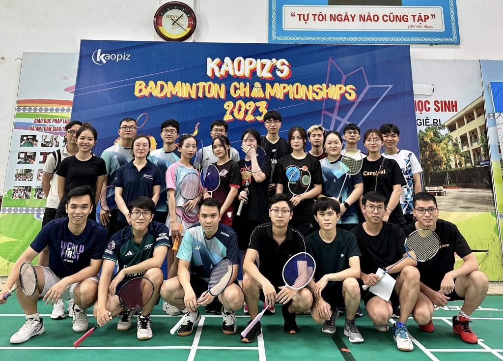 mage of KAOPIZ'S BADMINTON CHAMPIONSHIPS 2023 tournament with employees engaging in badminton matches.